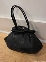 Front/side exterior of black leather purse with handles