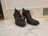 Oblique front view of both shoes showing leather uppers, laces, cap toes and heel shape