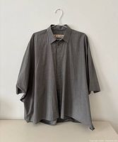 Full front view of grey oversized shirt on hanger