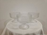 All three matching clear textured footed dessert bowls grouped