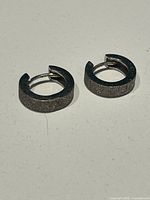 Pair of silver-tone textured hoop earrings top view