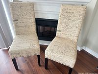 Two upholstered chairs in front of fireplace