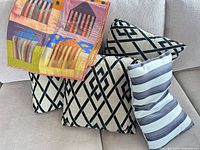 Quilt draped over three geometric pillows and one striped pillow on sofa