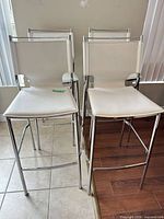 front view of four white chrome bar stools