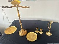 Entire lot showing balance scale, detached pan, trumpet candlestick, two small candlesticks