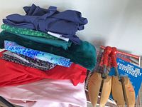 Stack of folded fabrics, books and shoe trees visible