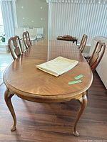 Full view of wood dining table with leaves inserted and folded tablecloth on top