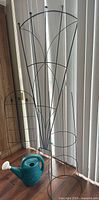 Tall cast iron trellis, small metal trellis, teal watering can visible