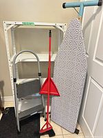 Overall lot showing shelf unit, step stool, broom, dustpan, ironing board