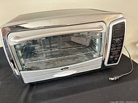 Front view of Oster digital toaster oven with power cord visible