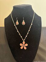 Full view of necklace and matching earrings on display stand