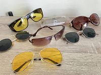 All six pairs of sunglasses and clip-on laid out on table