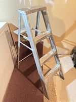 Full view of aluminum 3-step ladder standing open