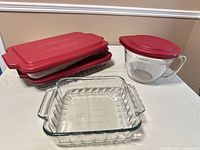 Lot overview showing two stacked 9 x 13 pans with lids, pitcher with lid, and 8 x 8 pan