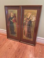 Both framed angel musician prints standing side by side