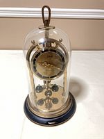 Full view of Schatz 400-day clock under glass dome on base