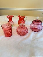 Front view of all five cranberry glass pieces