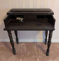 Front view of desk with top open showing drawer and cubbies