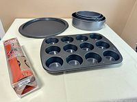 Group shot: pizza pan, muffin tin, nested springform pans, packaged Silpat mat