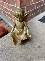 Front view of cast iron fairy with leaf dish and bird