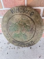 full view of round cement garden stone with inscription