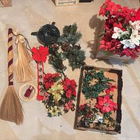 Group shot of all items laid out, showing tree stand, broom, angel ornament, bow with bells, greenery, poinsettia box