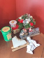 Group view showing centrepiece, tins, wooden skate, ceramic ornaments and Santa train