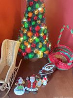 Lighted bauble tree, wicker sleigh, wicker basket, four metal ornaments visible