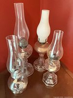 group shot of four coal oil lamps with chimneys