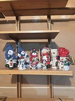 Full lineup of seven snowman figurines on shelf