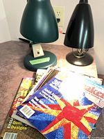 Two desk lamps and stack of quilting books on countertop