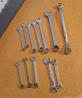 Group of 13 mixed imperial wrenches on cork surface
