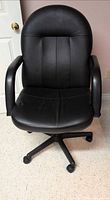 Front view of black faux leather swivel office chair