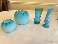 group shot of two blue satin rose bowls, cobalt translucent vase, light blue footed vase