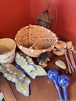 Overview of lot showing wicker basket, ceramic bowl, tin butterflies, lantern, watering globes, gnome figurine