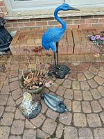 Group view: heron, girl with cat, planter, duck