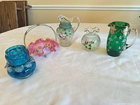 All five hand-painted glass items displayed on table