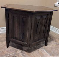 Front view of dark wood hexagonal side table with paneled doors