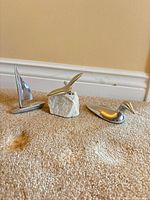 Three Hoselton aluminum sculptures: sailboat, bird on rock, duck