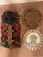 Overall view of carved wood plaque and two ceramic plates