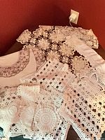 Assorted lace linens spread out showing variety of patterns and sizes