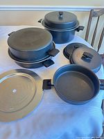 Entire cookware set laid out showing pots, lids, steam trays