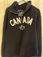 Front view of navy Canada pullover on hanger