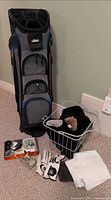 Full lot view with golf bag, basket of headcovers, gloves, towel, cleats and accessories