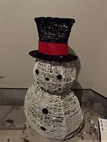 Front view of unlit wire snowman with hat and buttons visible