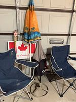 Lot overview showing two folding chairs, umbrellas, stand, Canada Day decor