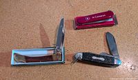 Overview of three pocket knives, two in boxes