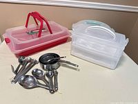 All carriers, devilled egg tray, measuring cups and spoons on table