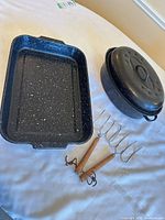 Group view of oval roaster with lid, rectangular roasting pan and four toasting forks