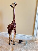 Full view of wooden giraffe, wood elephant, glass elephant